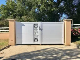 Portail aluminium, 2 vantaux de couleur blanc azuré. Zone déco : tôle découpe laser ORIENT