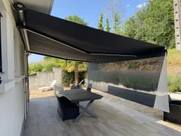 Banne pour terrasse OCEANIA, 2 bras, avec toile A, Sun’system + lumina led Larg 5950 mm x Avancée 3750 mm . Profils Alu laqués Gris anthracite RAL 7016 FT . Manœuvre électrique par moteur SOMFY SUNEA IO + un émetteur SITUO IO 5 Pure Variation . Côté de
